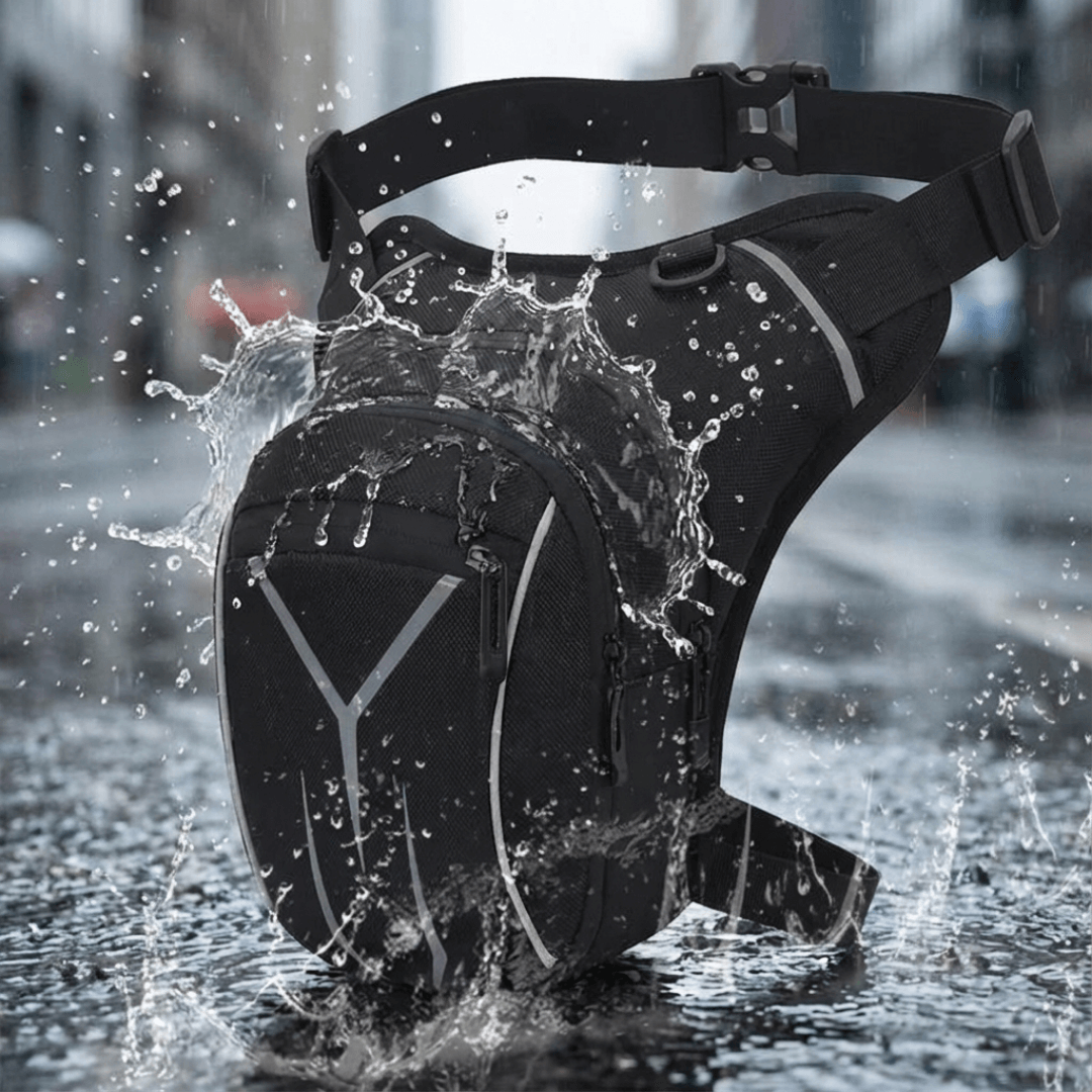 Schwarze Beintasche mit grauen Reflexstreifen, Hüftgurt und Beingurt, umgeben von Wasserspritzern auf nasser Straße