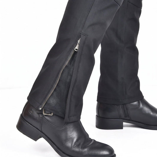 Schwarze Motorradhose mit geöffnetem Knöchelreißverschluss und Mesh-Futter, der Saum liegt über einem schwarzen Lederstiefel