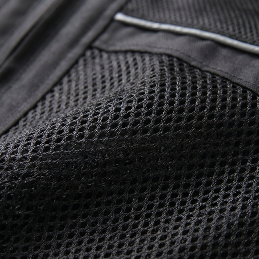 Nahaufnahme des Netzgewebes einer schwarzen Motorradjacke mit silbergrauem Reflexstreifen am oberen Rand und glattem Textil links daneben