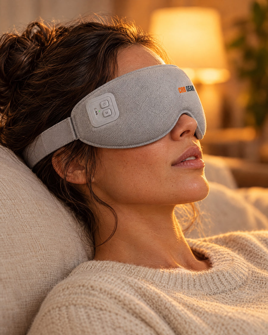 Woman relaxing in warm lamp light wearing the CRB GEAR Reset heated eye massager